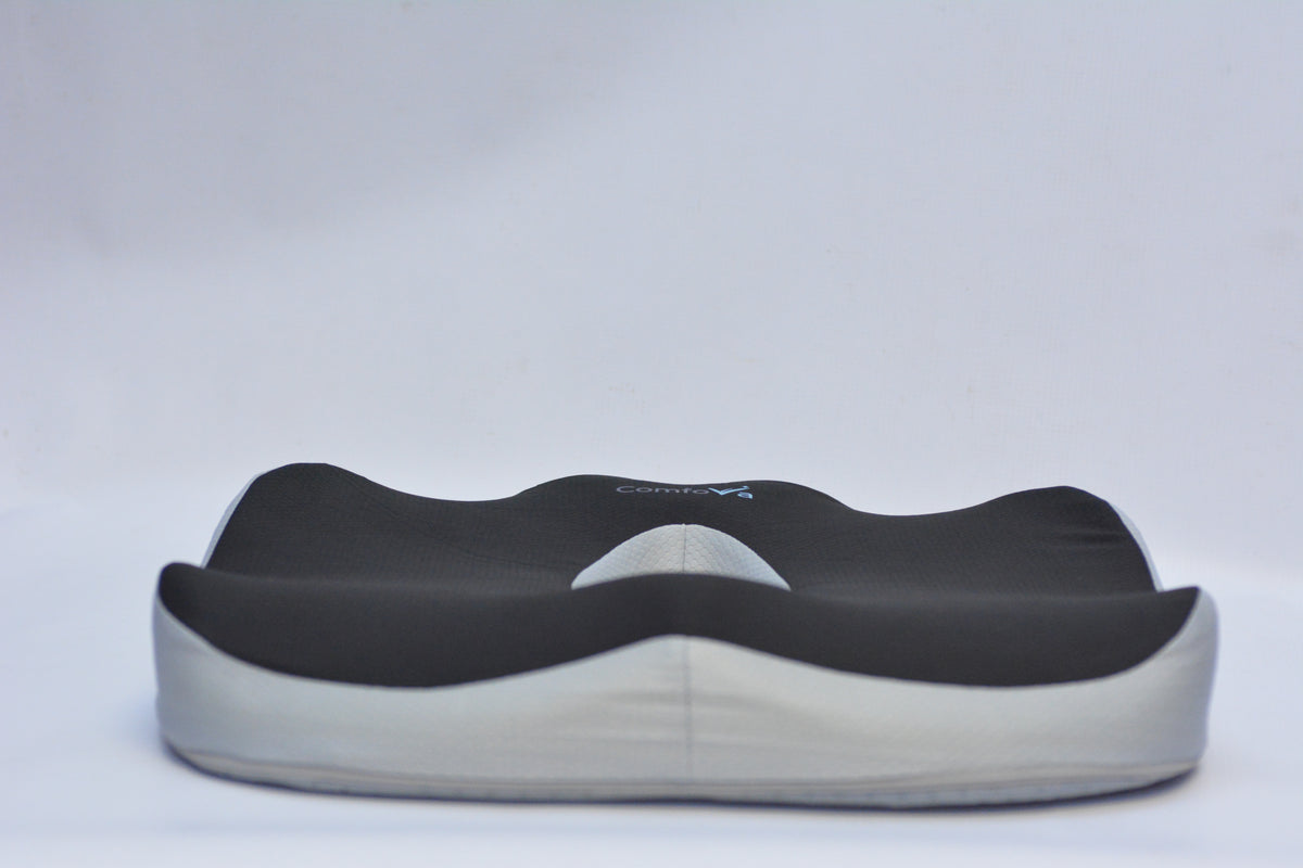 A contoured support cushion with a black top layer and a light gray base, shown against a plain light gray background.