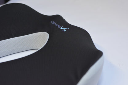 Close-up of a Contivo contoured support pillow with a black textured top and a white inner layer, showing the Contivo brand logo.