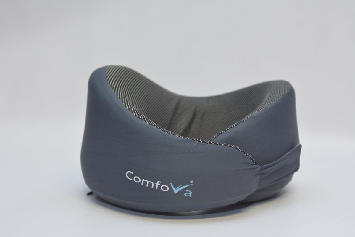 A dark gray ComfoVra neck support pillow with a textured gray inner lining and a white and blue logo on the front, set against a plain light gray background.