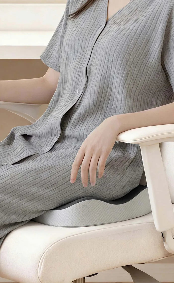 A woman seen from the side, sitting back on the cushion in an office chair